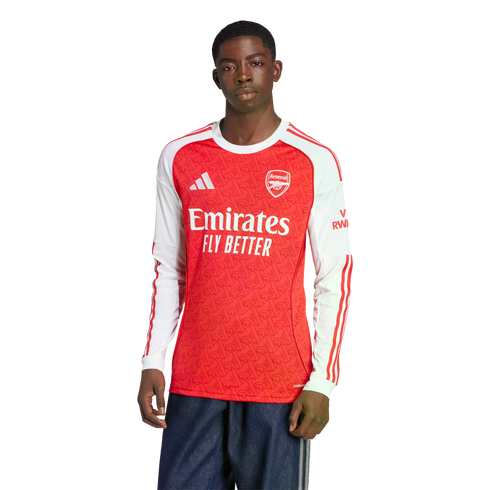 A man models a long-sleeved red and white Arsenal FC soccer jersey with the Emirates sponsor logo and dark blue athletic pants against a plain white background.