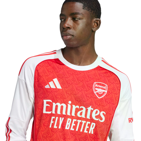 Close-up of a young man wearing a red and white Arsenal jersey with an Adidas logo and "Emirates FLY BETTER" text, looking sideways against a white background.