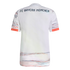 Back view of a white FC Bayern München jersey with dark blue text and orange and grey linear patterned accents on the lower back and sleeves.