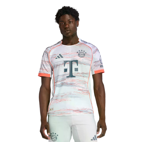 A man modeling an Adidas FC Bayern Munich soccer kit featuring a patterned white jersey and matching shorts against a plain white background.