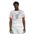 A man modeling an Adidas FC Bayern Munich soccer kit featuring a patterned white jersey and matching shorts against a plain white background.