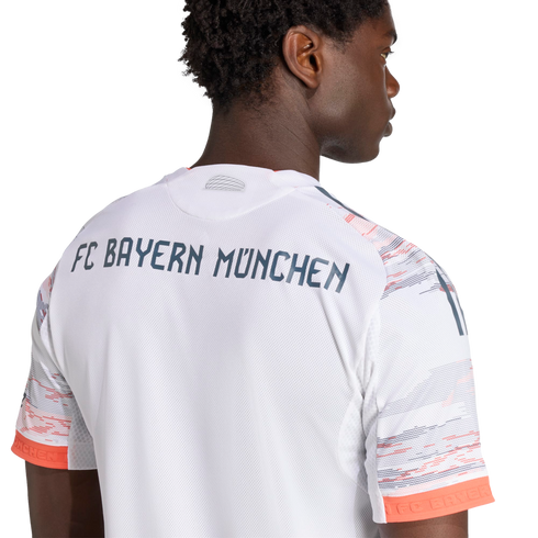 The back of a man wearing a white FC Bayern München soccer jersey with navy lettering and orange-patterned sleeves.