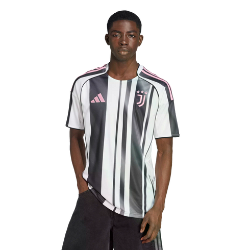 A man wearing a black and white striped Juventus soccer jersey with pink accents, standing against a white background.
