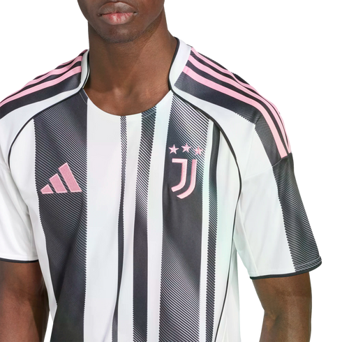 Close-up of a person wearing a white and black striped Juventus soccer jersey with pink logos.