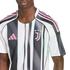 Close-up of a person wearing a white and black striped Juventus soccer jersey with pink logos.