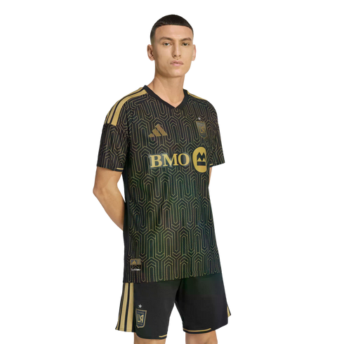 A man wearing a black and gold LAFC soccer uniform with a geometric pattern and BMO sponsor logo, set against a solid black background.