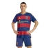 A man models a blue and red striped Real Salt Lake soccer jersey and blue shorts. He stands with hands on his hips against a black background.