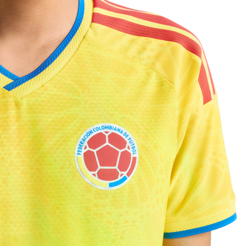 Yellow Colombian national soccer jersey with blue trim and red shoulder stripes, featuring the official federation crest on the chest.