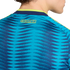 Close-up of the back of a teal and blue patterned soccer jersey with "COLOMBIA" in yellow text near the lime green and navy collar.