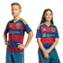 Two children, a boy and a girl, pose in matching navy and red striped soccer jerseys with gold logos against a black background.