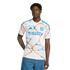 A man in a white San Diego FC soccer jersey with orange and blue patterns and "DIRECTV" sponsor, wearing blue jeans against a solid black background.