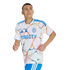 A man wearing a white San Diego FC soccer jersey with blue and orange marble patterns and DirecTV logo, in a running pose against a black background.