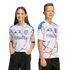 Two youth models wear white San Diego FC soccer jerseys with an orange and blue marbled pattern and the DIRECTV logo. They are posed against a black background.