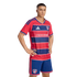 Male model posing in the FC Dallas home soccer kit, featuring a red and blue striped jersey with "children'shealth" logo and matching blue shorts.