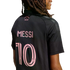 Back view of a person with long braids wearing a black Inter Miami jersey with pink lettering for "FREEDOM TO DREAM", "MESSI", and the number 10 on a black background.