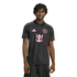 A man with dreadlocks wearing a black Inter Miami CF polo shirt with pink Adidas, team crest, and Royal Caribbean logos, isolated against a black background.
