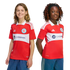 Two smiling children wearing red and white Chicago Fire FC soccer jerseys with the Carvana sponsor logo.