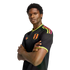 Man with arms crossed wearing a black FPF jersey with neon yellow and orange accents, against a black background.