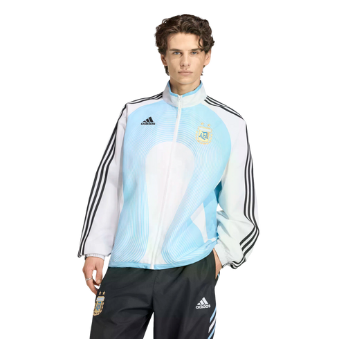 Man modeling a light blue and white Adidas Argentina national team track jacket and black track pants against a black background.
