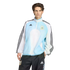 Man modeling a light blue and white Adidas Argentina national team track jacket and black track pants against a black background.