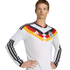 A man in a long-sleeved white German national team football jersey with black, red, and gold stripes across the chest, posing against a black background.