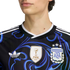 Close-up of a person in a black and blue patterned Argentina jersey featuring the 2022 FIFA World Champions patch, Adidas Trefoil logo, and the AFA crest with three stars.