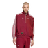 A person with short blonde hair models a maroon Adidas x Arsenal tracksuit with white stripes and logos against a solid black background.