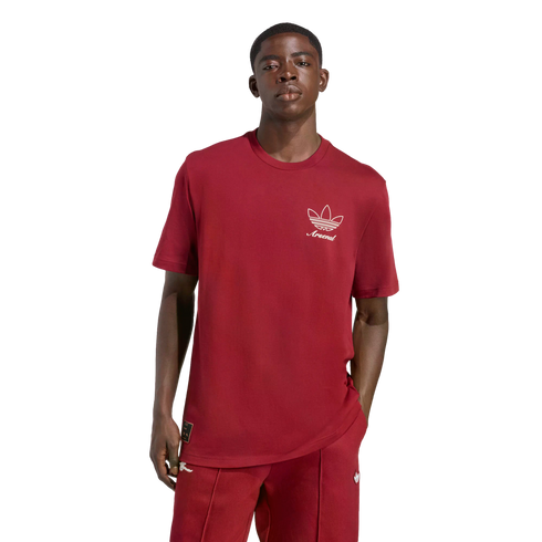 A man wearing a maroon t-shirt with a white Adidas trefoil logo and "Arsenal" text, paired with matching track pants, posed against a solid black background.
