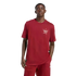 A man wearing a maroon t-shirt with a white Adidas trefoil logo and "Arsenal" text, paired with matching track pants, posed against a solid black background.