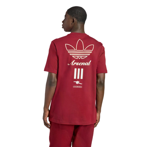 Rear view of a man in a maroon Adidas t-shirt featuring an off-white trefoil logo, "Arsenal" script, three vertical bars, and a cannon emblem.