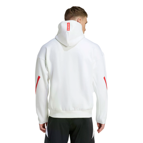 Rear view of a man wearing a white hoodie with red sleeve stripes and a red "MIA SAN MIA" label on the hood, paired with black athletic pants.