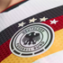 Close-up of the Germany national football team crest on a jersey. The circular logo features an eagle and four stars above black, red, and gold stripes.
