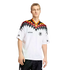 A man models a white Adidas Germany football jersey featuring a black, red, and yellow diamond pattern across the shoulders and neck.