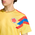 Close-up of a person wearing a yellow Colombia national football team jersey with the team crest and red and blue patterns on the sleeve and collar.