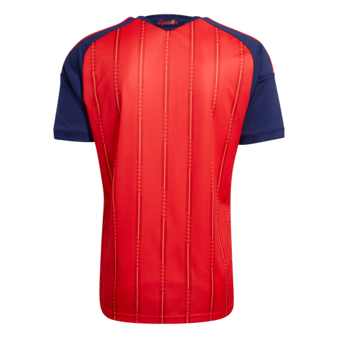 Back view of a red sports jersey with navy blue sleeves, featuring yellow vertical stripes and the word "España" printed in gold below the neckline.