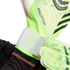 Close-up of a person fastening the white wrist strap of a lime green Predator goalkeeper glove.
