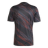 Rear view of a short-sleeved jersey featuring a dark grey base and a diagonal pattern of red and blue brushstrokes.
