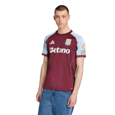 Male model wearing the claret and blue 2024-25 Aston Villa home kit by Adidas with Betano sponsor logo against a black background.