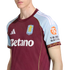 Close-up of a person wearing an Aston Villa home football jersey, featuring a maroon body, light blue sleeves, and the Betano sponsor logo.