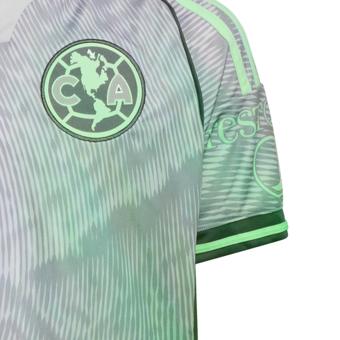 Close-up of a grey and mint green Club América soccer jersey featuring a jagged wavy pattern and the team's circular crest on the chest.