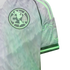 Close-up of a grey and mint green Club América soccer jersey featuring a jagged wavy pattern and the team's circular crest on the chest.
