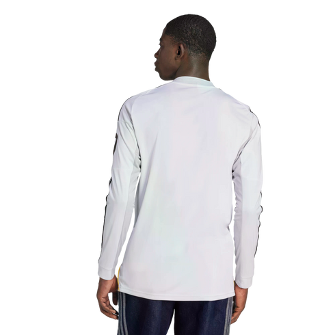 Rear view of a man wearing a white long-sleeved athletic shirt with black sleeve stripes and dark blue shorts.