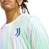 A person wears a Juventus soccer jersey featuring pastel-colored vertical stripes and the team's "J" logo on the chest.