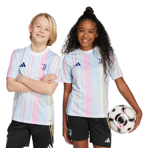 Two children smile in matching blue, pink, and yellow striped Juventus soccer kits. The girl holds a soccer ball against a white background.
