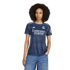 A woman with a large afro wears a navy blue Real Madrid soccer jersey and blue jeans against a white background.