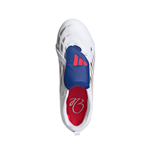 Top-down view of a white Adidas shoe with a blue lace cover and red stripes. The red interior features a white signature. Set against a solid black background.