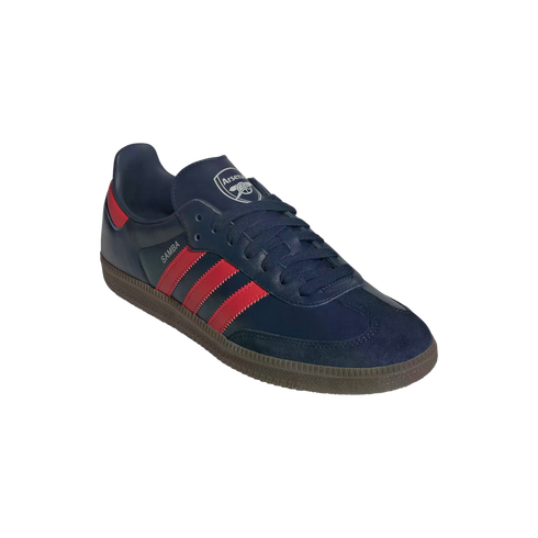 A navy blue Adidas Samba shoe with three red stripes and gum rubber sole, featuring the Arsenal FC crest on the tongue.