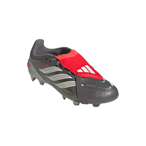 Grey Adidas Predator soccer cleat featuring silver stripes, a red fold-over tongue with a white logo, and a black elastic strap under the sole.