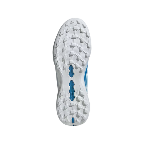 An overhead, centered, full shot of the bottom of a white and blue athletic shoe with white cleats, against a black background.