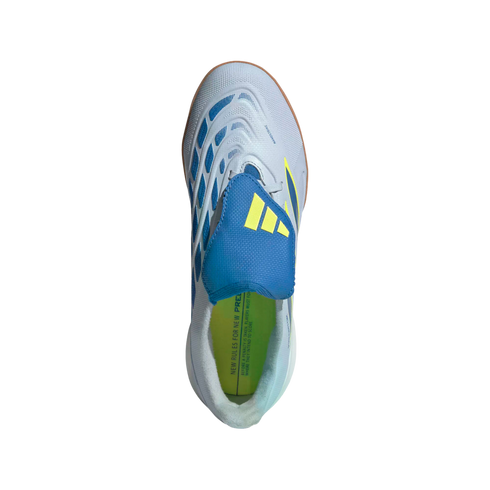 A top-down view of a light gray Adidas Predator indoor soccer shoe featuring a blue tongue cover with yellow stripes, blue textured accents, and a lime green insole against a black background.
